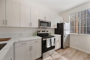 Kitchen with white cabinets and a black stove top.